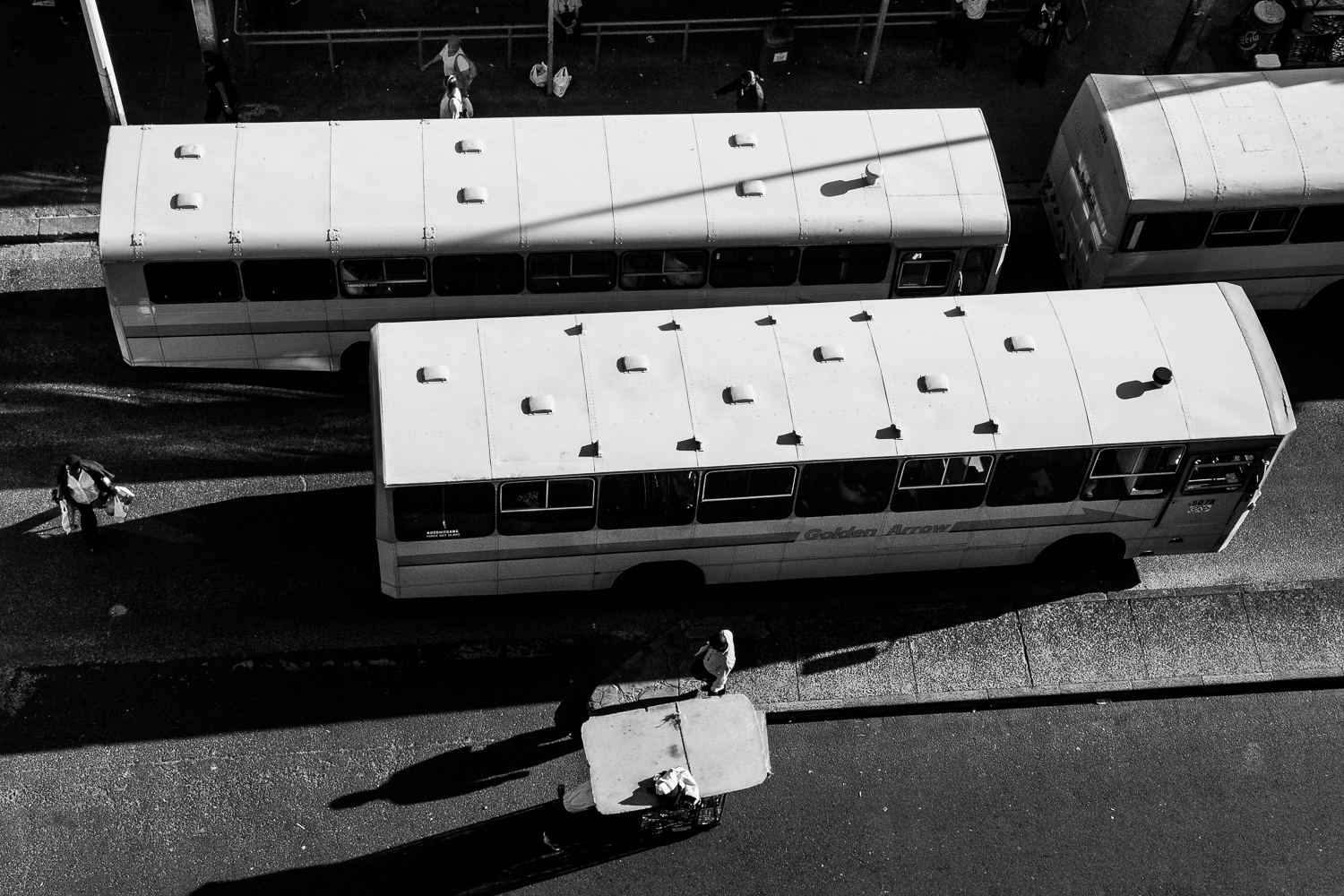 Busses leaving the central bus terminus, while stall owners are moving their temporary shop, Cape Town, 2009.